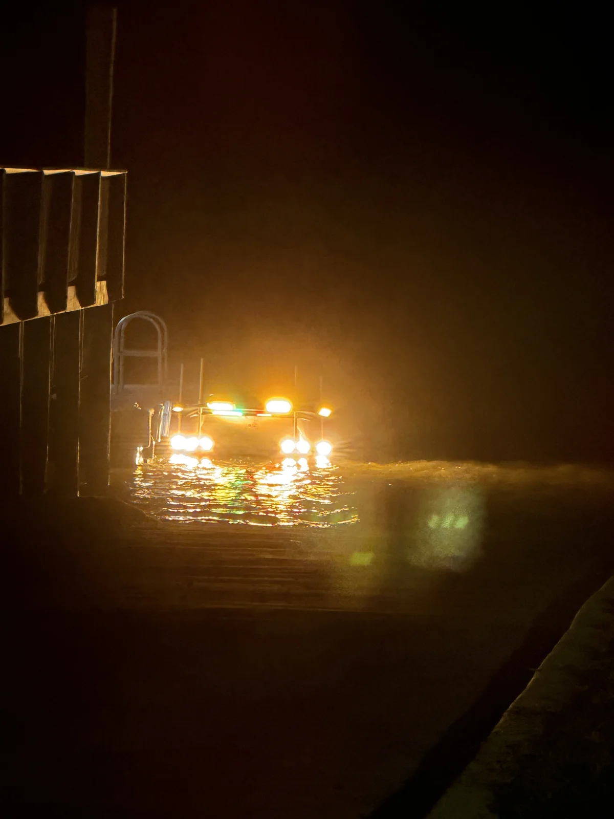 The full rig lit up at the dock, above-water lights and underwater lights both running
